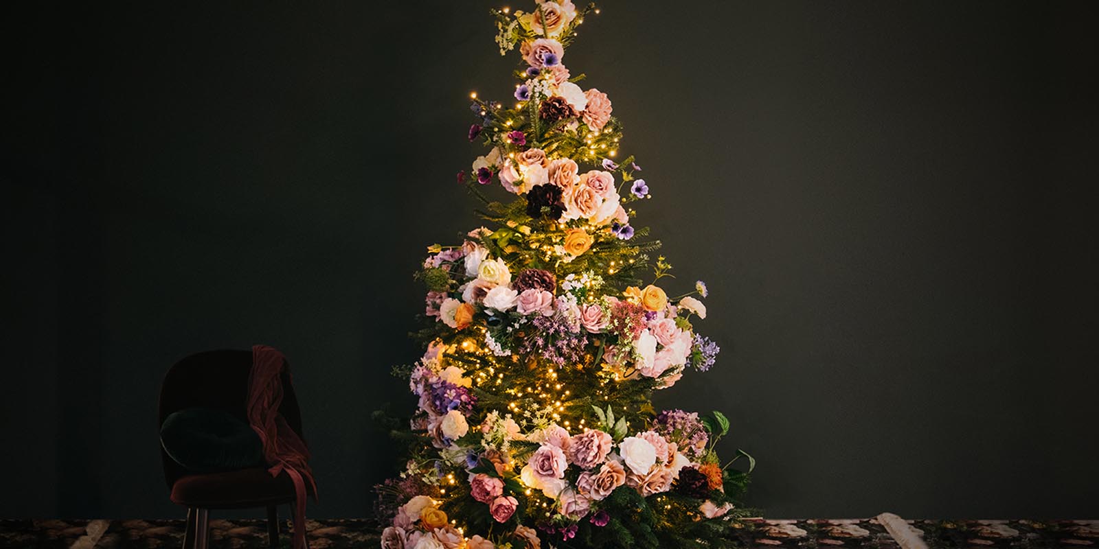 leuchtender Weihnachtsbaum mit Blumen geschmückt